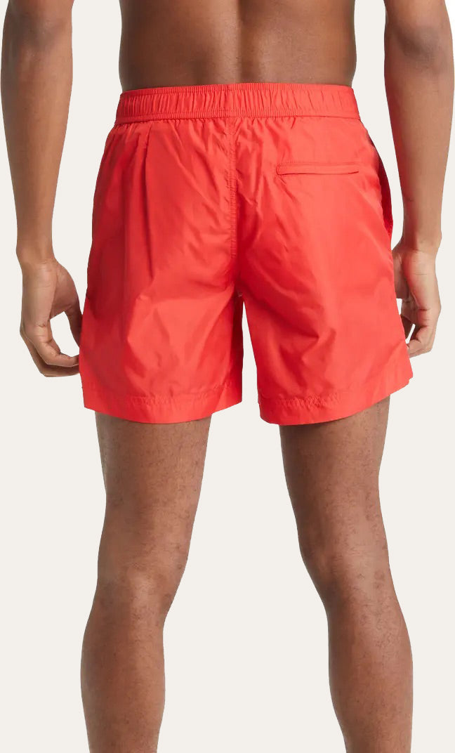 Model wearing red Easton Logo Embroidered tailored swim shorts by Prince & Bond